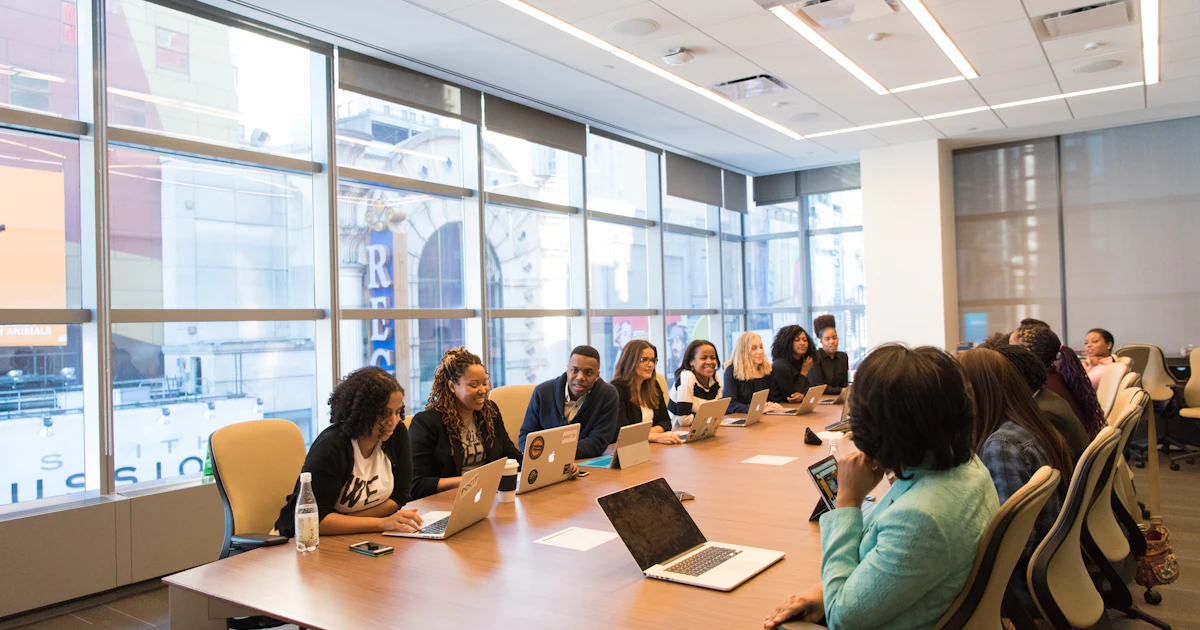 A group of people working together at a conference table with laptops
