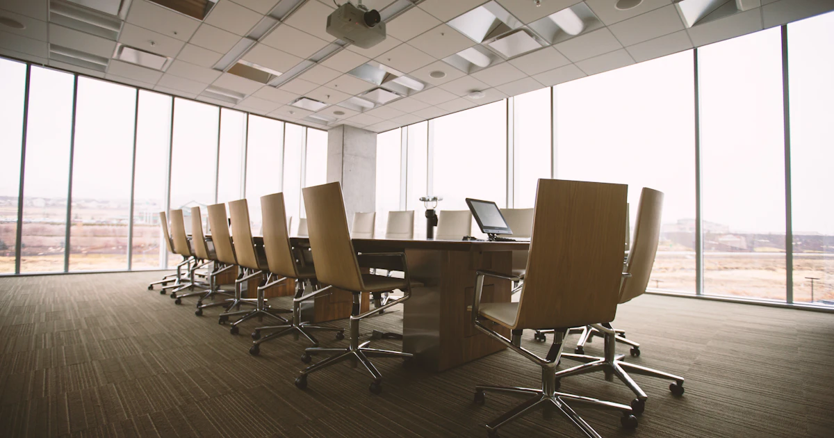 An empty conference room with a long table and chairs, ready for a board meeting